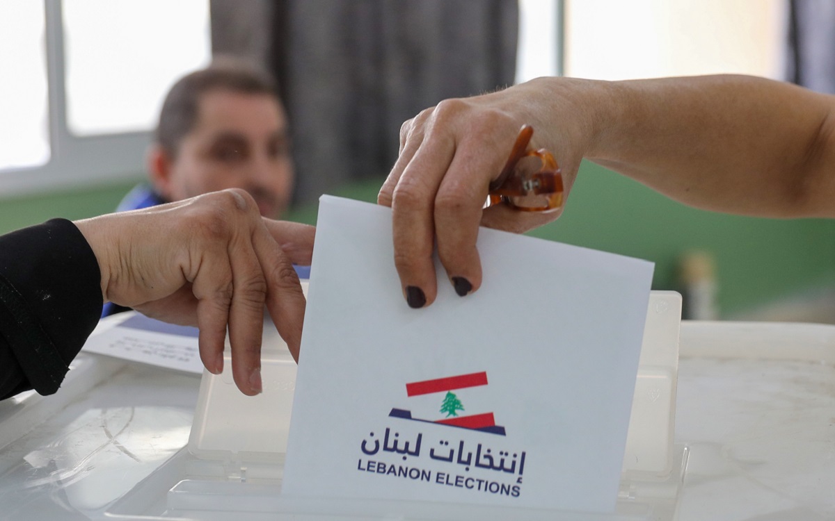 A Lebanese woman casts her ballot for the parliamentary election at a polling station in the Lebanese capital Beirut, on May 15, 2022. - Lebanon voted in its first election since multiple crises dragged it to the brink of failed statehood, with the ruling elite expected to comfortably weather public anger. The parliamentary election is a first test for opposition movements spawned by an unprecedented anti-establishment uprising in 2019 that briefly raised hopes of regime change in Lebanon. (Photo by IBRAHIM AMRO / AFP) / The erroneous mention[s] appearing in the metadata of this photo by IBRAHIM AMRO has been modified in AFP systems in the following manner: [Lebanese woman] instead of [a Shiite cleric]. Please immediately remove the erroneous mention[s] from all your online services and delete it (them) from your servers. If you have been authorized by AFP to distribute it (them) to third parties, please ensure that the same actions are carried out by them. Failure to promptly comply with these instructions will entail liability on your part for any continued or post notification usage. Therefore we thank you very much for all your attention and prompt action. We are sorry for the inconvenience this notification may cause and remain at your disposal for any further information you may require.